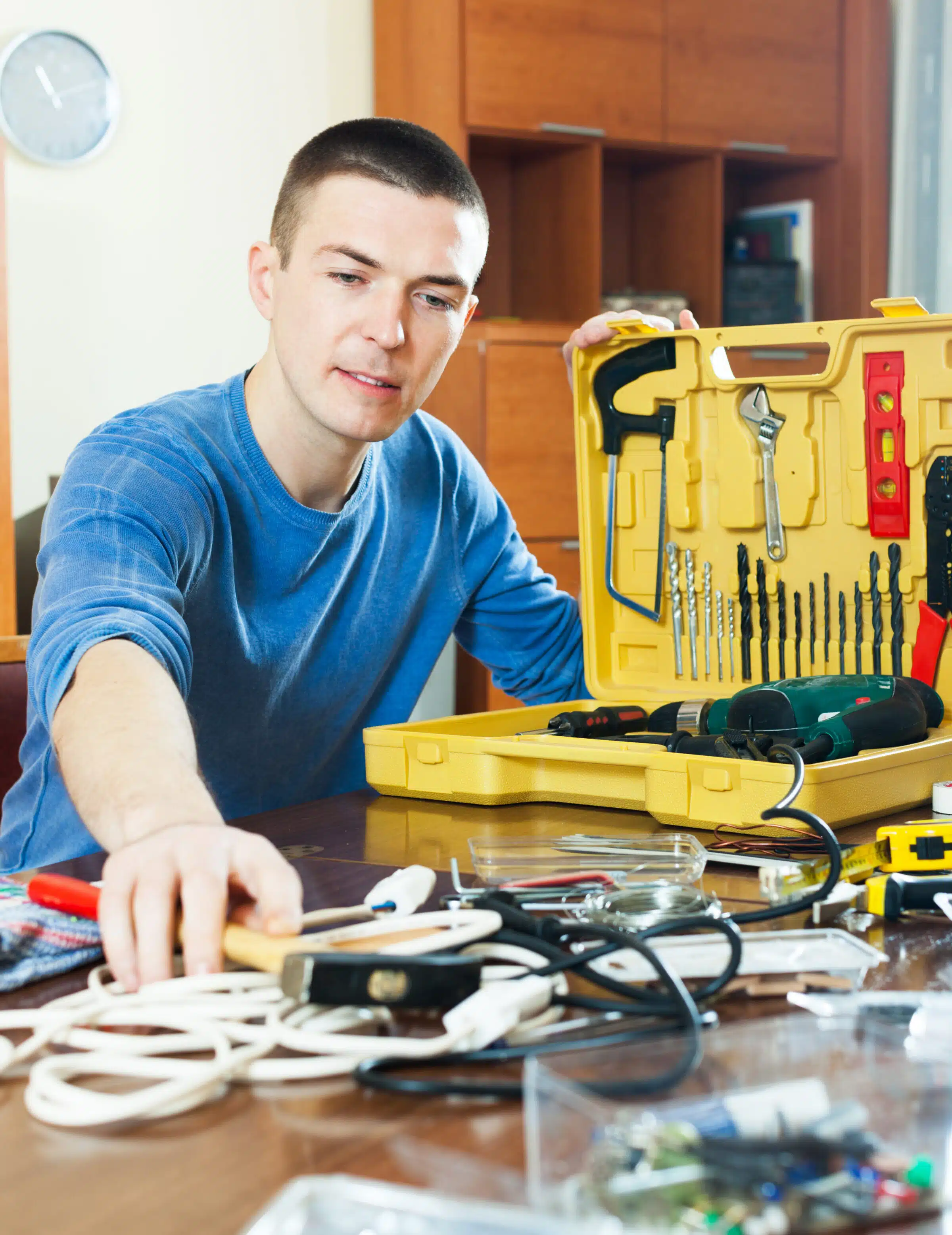 Handsome man with toolbox reaching for hammer